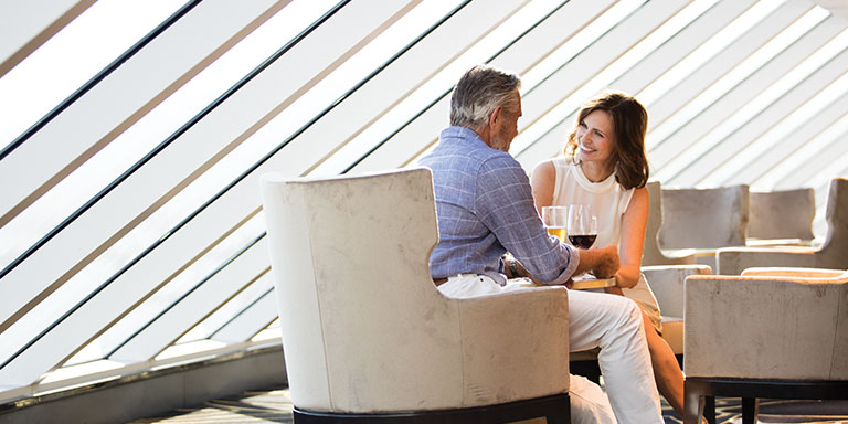 a couple enjoying a drink aboard a regent seven seas cruise ship