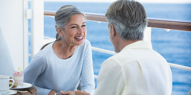 a couple on their balcony onboard a regent ship