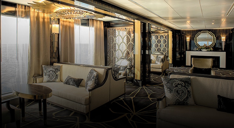 A photo of a luxurious bar or lounge on a Regent Seven Seas cruise ship. The photo features comfortable seating, elegant décor, and a variety of drinks on display behind a staffed bar. (Photo Courtesy Regent Seven Seas Cruises)