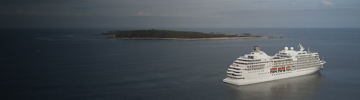 barco de crucero de regent en el océano con una isla