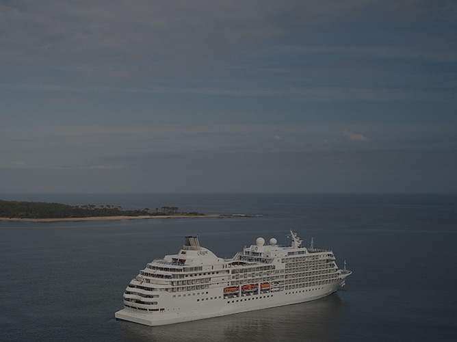 regent cruise ship in ocean with island