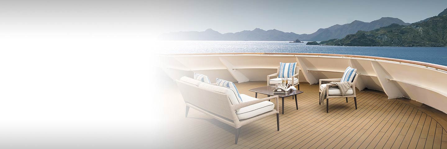 lounge furniture outside on the deck overlooking the ocean aboard a cruise ship
