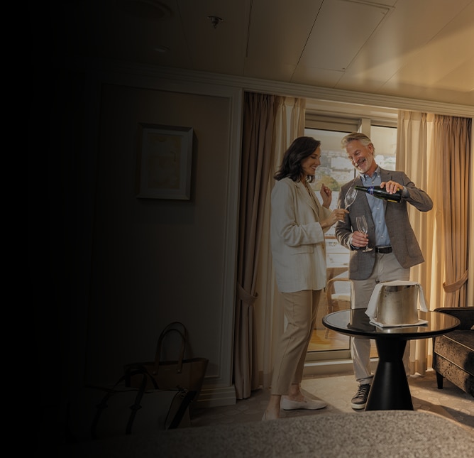 Couple pouring themselves wine and enjoying their Regent cruise