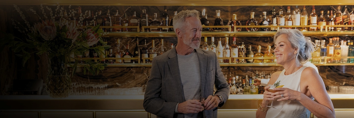 couple laughing with drinks in their hand aboard a Regent ship