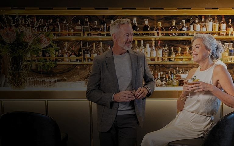 couple laughing with drinks in their hand aboard a Regent ship