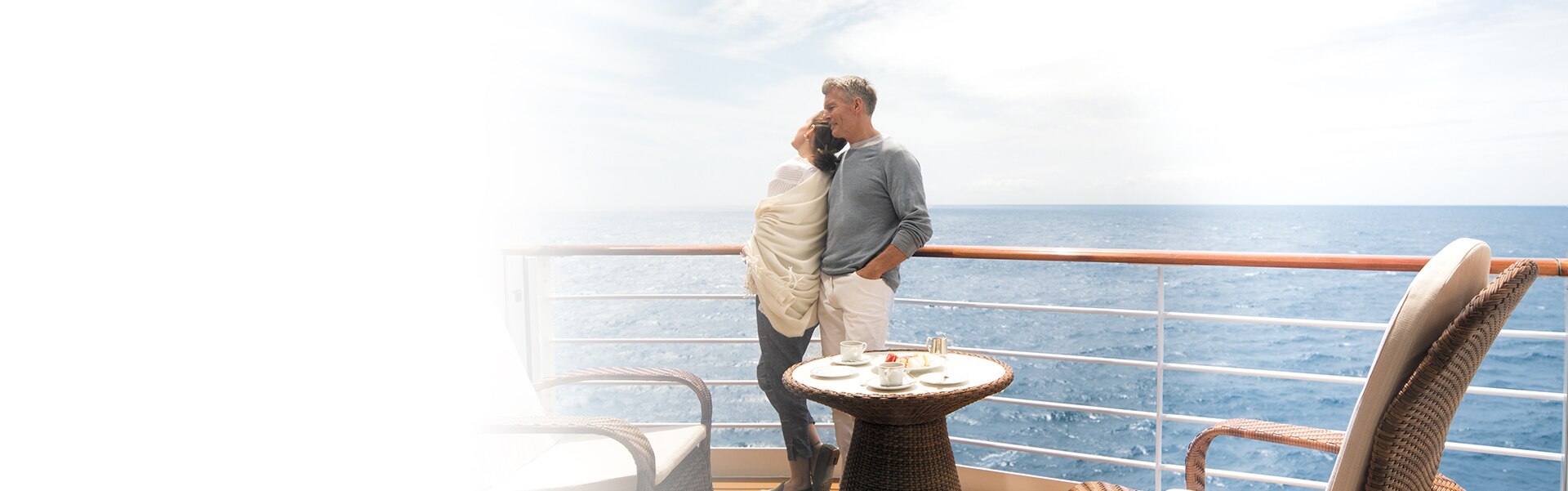 couple enjoying the ocean breeze on the balcony of a regent seven seas cruises