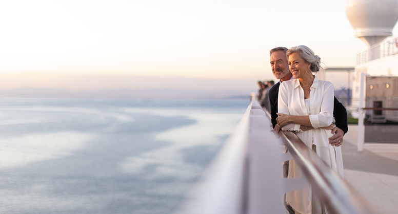 Couple looking out to the sea aboard a luxury cruise ship with Regent Seven Seas Cruises