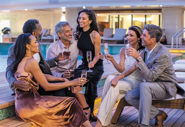 Group of friends enjoying drinks at night on a Regent cruise