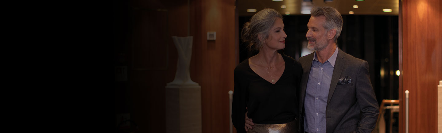 a couple walking through the spacious common spaces of a regent seven seas cruise ship