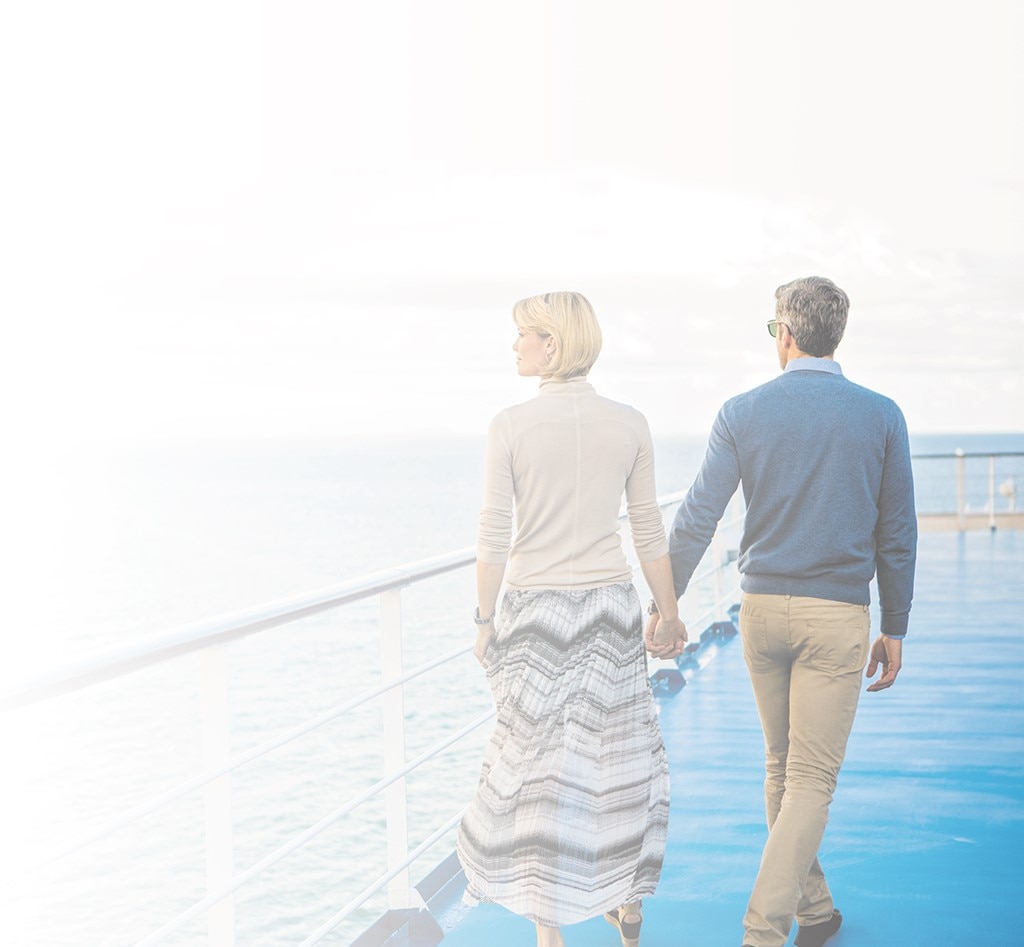 Couple holding hands walking on a Regent cruise ship