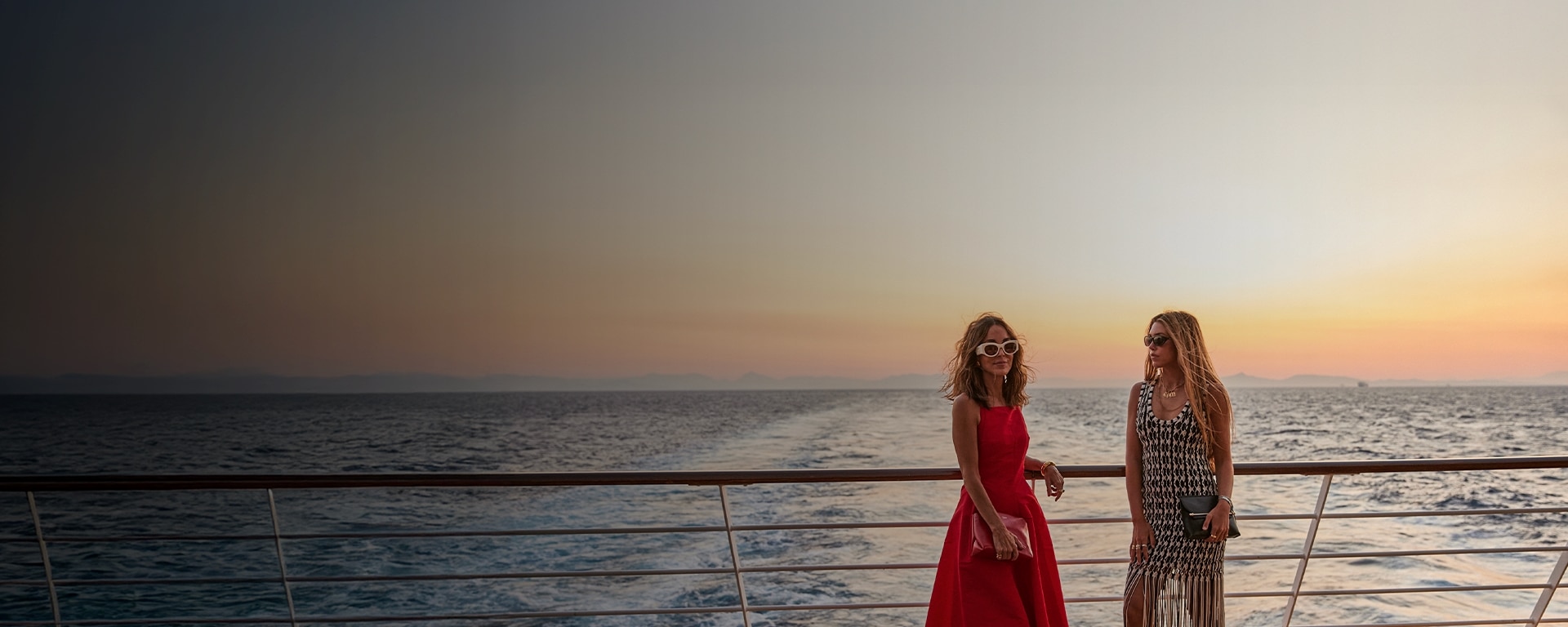 friends enjoying the sunset views from The World's Most Luxurious Fleet