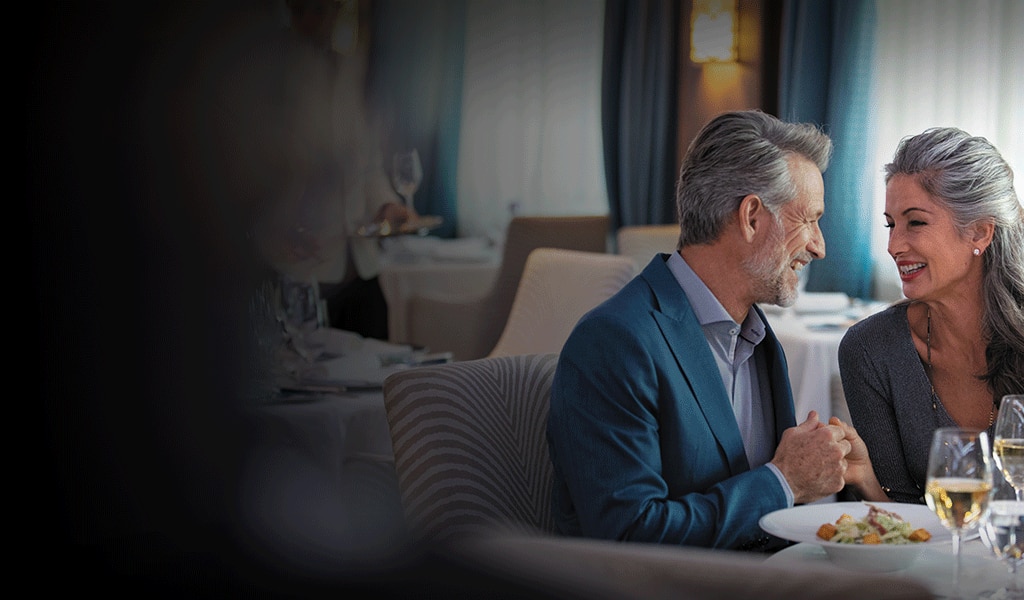 Couple admiring each other while enjoying fine dining aboard a Regent ship