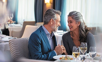 Couple admiring each other while enjoying fine dining aboard a Regent ship