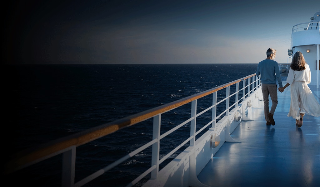 Couple holding hands while walking on a luxury Regent cruise ship