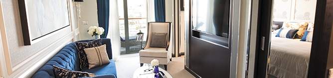 espaciosa suite de crucero decorada con detalles en azul y vista al balcón