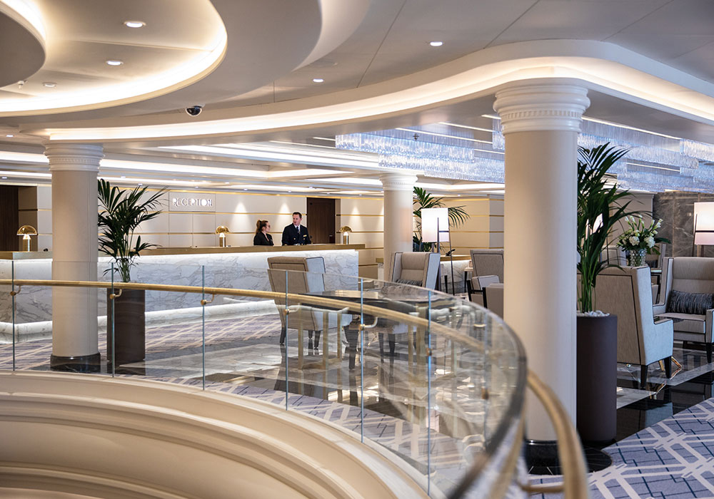 the reception counter with two crew members and a large seating area